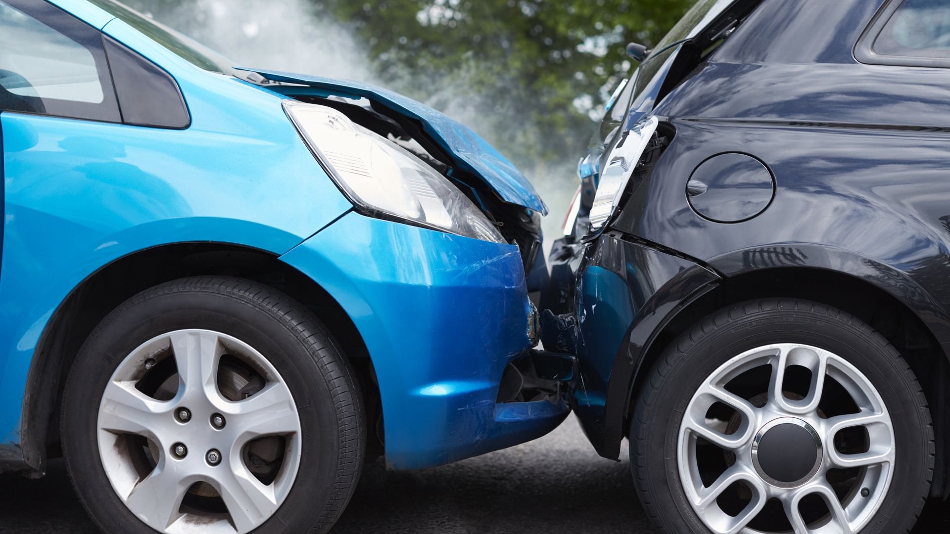 Two cars in a severe collision, blue and black vehicles damaged