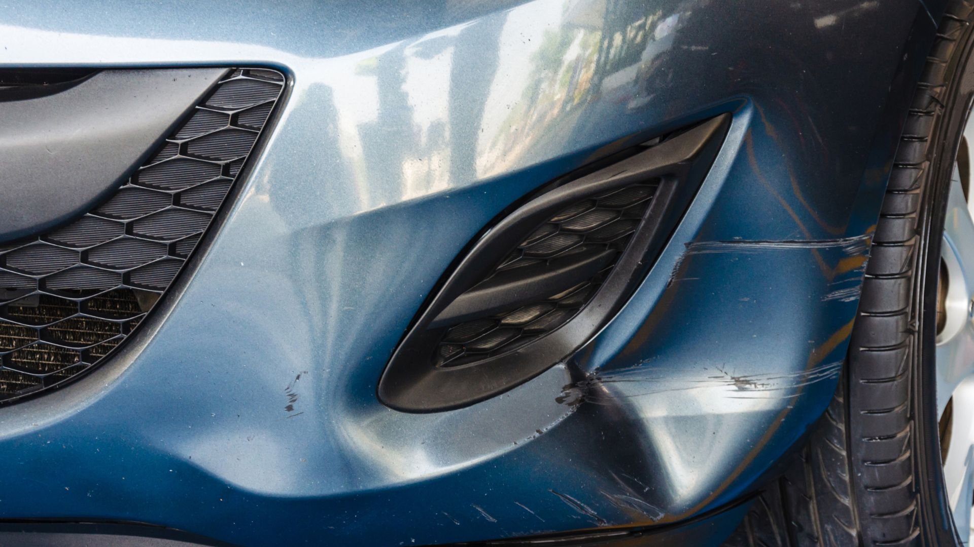 Close-up of blue car with sleek metallic surface and black air vents